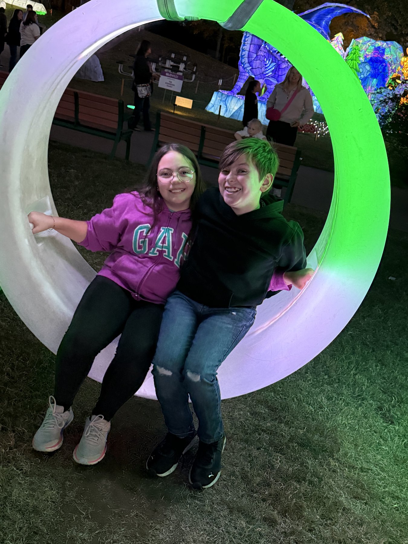 Two children enjoying a glowing outdoor installation